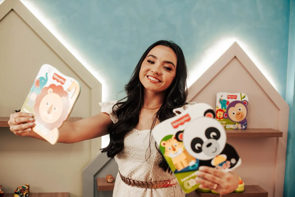 Psicóloga da Imagine com livros infantis na sala de brincar da clínica